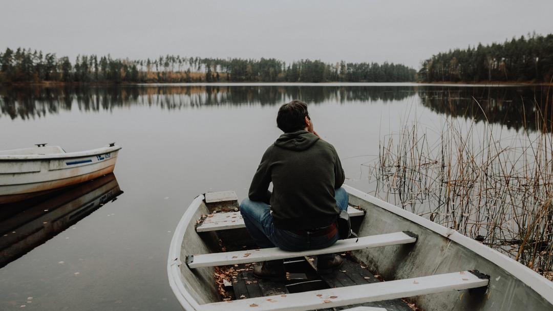 Bild på man i en roddbåt.